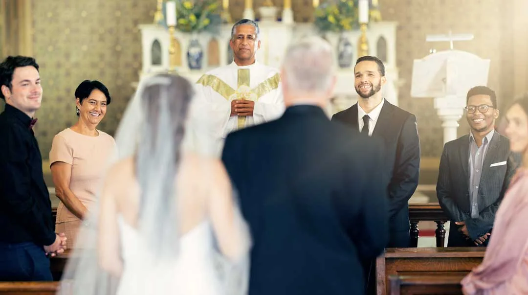 Married couple with priest at the altar for religious wedding